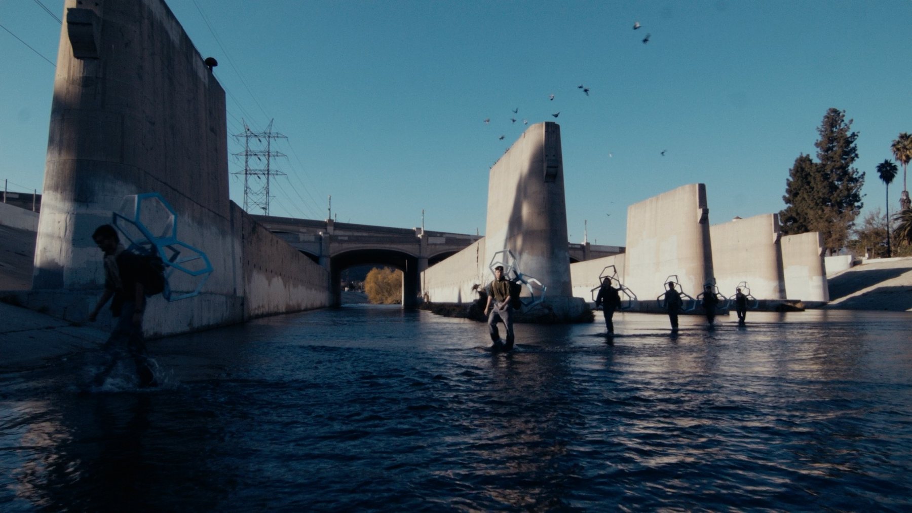 Still from film documentation, wireframe forms carried across the LA River channel, Glendale