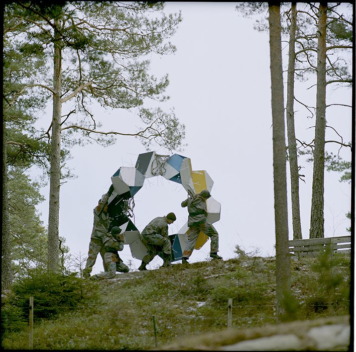 Figure in a raised pose against the hexagonal structure, Isesjø