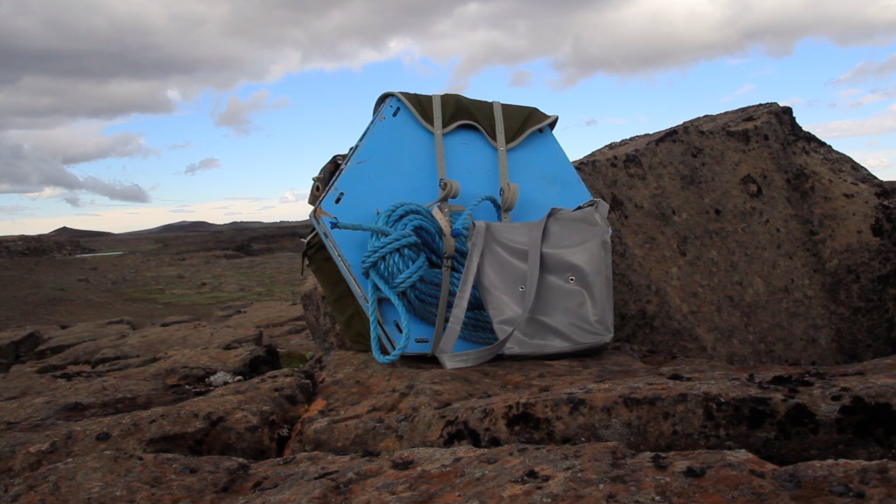 Blue ring installed against dark volcanic rock, Námafjall