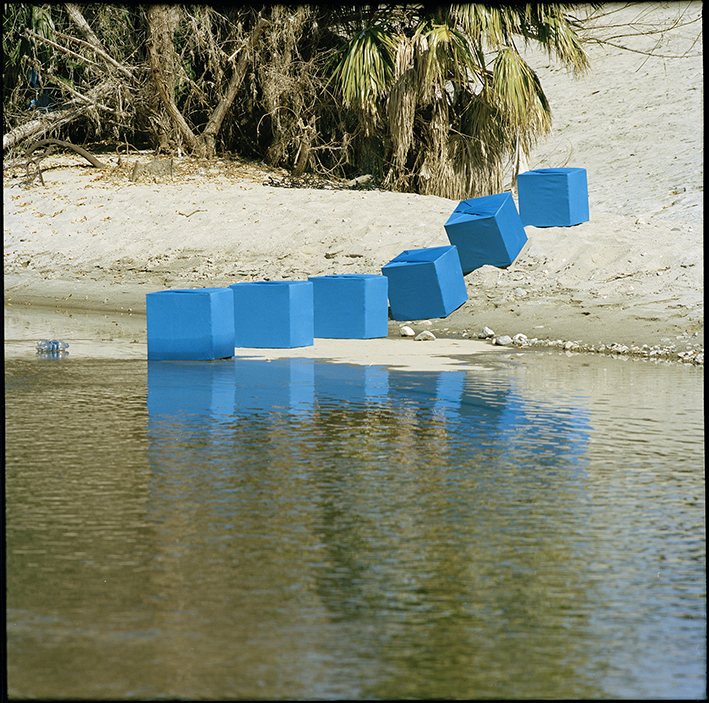 Line of blue cube markers laid across the Los Angeles River at Frogtown