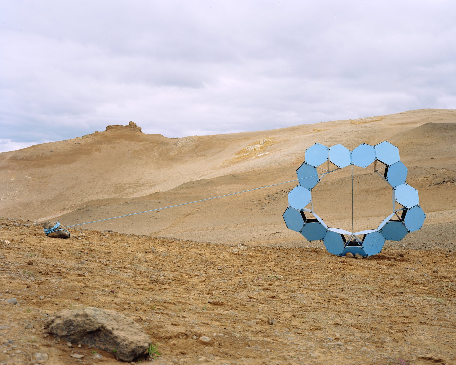Large blue ring sculpture on volcanic terrain, Námafjall