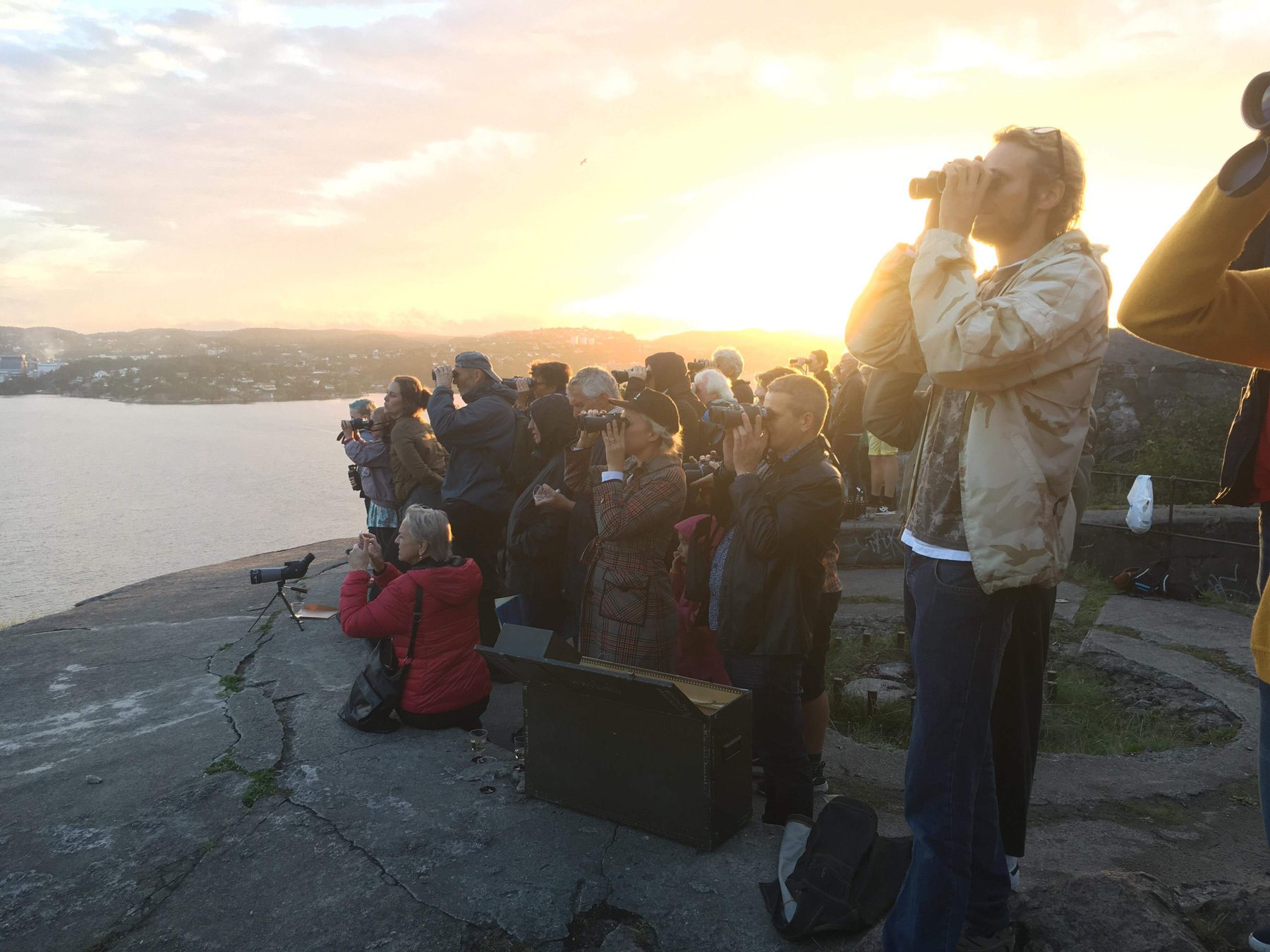 Audience with binoculars looking out from Vestre Batteri, Odderøya
